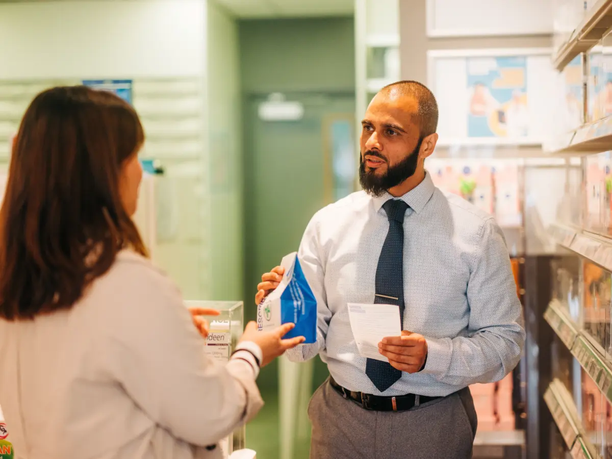 Pharmacist-giving-prescription-bag.webp